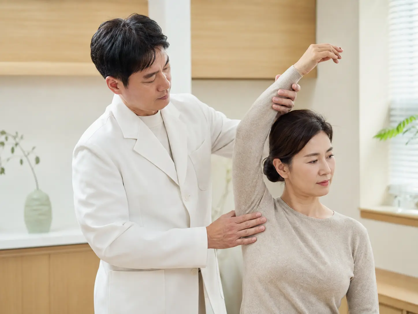 환자의 어깨 움직임과 가동범위를 확인하는 진찰 장면